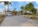 Charming single-story home featuring a well-manicured yard with lush tropical landscaping and an inviting entrance at 504 Driftwood E Dr, Palm Harbor, FL 34683
