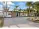 Charming single-story home featuring a well-manicured yard with lush tropical landscaping and an inviting entrance at 504 Driftwood E Dr, Palm Harbor, FL 34683