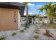 Charming single-story home featuring wood facade with home address and well-manicured tropical landscaping at 504 Driftwood E Dr, Palm Harbor, FL 34683