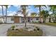 Charming single-story home featuring a well-manicured yard with lush tropical landscaping and an inviting entrance at 504 Driftwood E Dr, Palm Harbor, FL 34683