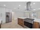 Modern kitchen featuring stainless steel appliances, sleek cabinetry, and a functional island with a cooktop at 504 Driftwood E Dr, Palm Harbor, FL 34683