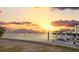 Waterfront views at sunset, featuring a boat docked at the property's private pier at 504 Driftwood E Dr, Palm Harbor, FL 34683