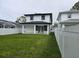 Spacious backyard with lush green grass, a pristine white fence, and a modern two-story home at 5730 66Th Ln N, St Petersburg, FL 33709