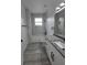 Well-lit bathroom featuring double sink vanity, marble-look shower, and modern fixtures at 5730 66Th Ln N, St Petersburg, FL 33709