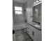 Modern bathroom featuring a tub with a shower, white marble tile and gray quartz countertop, creating a sleek design at 5730 66Th Ln N, St Petersburg, FL 33709