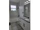 Modern bathroom featuring a tub with a shower, white marble tile and gray quartz countertop, creating a sleek design at 5730 66Th Ln N, St Petersburg, FL 33709