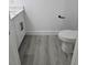Clean bathroom design showcasing sleek wood flooring and a white toilet at 5730 66Th Ln N, St Petersburg, FL 33709