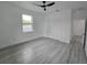 Large bedroom with modern ceiling fan, closet, and light gray laminate flooring at 5730 66Th Ln N, St Petersburg, FL 33709
