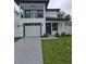 Two-story home with white exterior, black trim, balcony, blue front door, well-kept lawn and driveway at 5730 66Th Ln N, St Petersburg, FL 33709