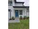 Close up of front porch with blue door, modern fixtures, landscaping and the address number at 5730 66Th Ln N, St Petersburg, FL 33709