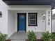 Close up of front porch with blue door, modern fixtures, landscaping and the address number at 5730 66Th Ln N, St Petersburg, FL 33709
