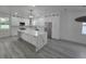 A modern kitchen with an island, stainless steel appliances, and quartz countertops at 5730 66Th Ln N, St Petersburg, FL 33709