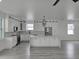 Bright kitchen features white cabinets, stainless steel appliances, gray flooring and a large center island at 5730 66Th Ln N, St Petersburg, FL 33709