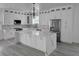 Bright kitchen features white cabinets, stainless steel appliances, gray flooring and a large center island at 5730 66Th Ln N, St Petersburg, FL 33709