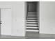 Modern staircase with wood treads and white risers, complemented by a white door and wood flooring at 5730 66Th Ln N, St Petersburg, FL 33709