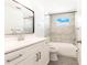 Bright bathroom showcasing stone countertop, a tiled shower and a large mirror at 6311 Seabreeze Dr, Port Richey, FL 34668