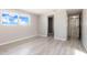 Light filled bedroom with a window, vinyl flooring, and a bathroom and hallway entrances at 6311 Seabreeze Dr, Port Richey, FL 34668