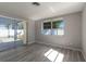 Cozy bedroom features wood-look floors, neutral walls, and ample natural light from a sliding glass door at 6311 Seabreeze Dr, Port Richey, FL 34668