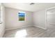 Bright bedroom featuring gray walls, wood-look floors and a window at 6311 Seabreeze Dr, Port Richey, FL 34668