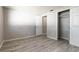 Clean bedroom with vinyl wood floors, neutral gray walls, and access to a closet and bathroom at 6311 Seabreeze Dr, Port Richey, FL 34668