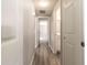 Hallway featuring gray walls and wood-look floors, with doorways into other rooms at 6311 Seabreeze Dr, Port Richey, FL 34668