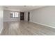 Neutral living room showcasing wood-look floors, a front window, and entry door for comfortable living at 6311 Seabreeze Dr, Port Richey, FL 34668