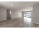 Spacious living room with wood-look flooring, neutral walls, and natural light from large windows at 6311 Seabreeze Dr, Port Richey, FL 34668