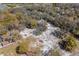 Aerial view of estate featuring a white sand equestrian area, mature trees, pond, pool and home at 6718 Watson Rd, Riverview, FL 33578