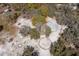 Aerial view of estate featuring a white sand equestrian area, mature trees, workshop and stable at 6718 Watson Rd, Riverview, FL 33578