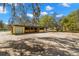 Outdoor barn structure featuring a garage door and access to stalls at 6718 Watson Rd, Riverview, FL 33578