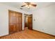 Bedroom boasts wood floors, ceiling fan, and wooden closet doors at 6718 Watson Rd, Riverview, FL 33578