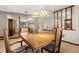 This dining room shows a mirror wall, decorative hanging lamp, and view into the kitchen and living room at 6718 Watson Rd, Riverview, FL 33578