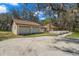 Home with a two car garage and a long driveway surrounded by mature trees covered in Spanish moss at 6718 Watson Rd, Riverview, FL 33578