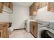 Functional laundry room features wooden cabinets, sink, and modern appliances at 6718 Watson Rd, Riverview, FL 33578