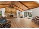 The home's living room offers a stone fireplace, beamed ceilings, and natural light from the back patio at 6718 Watson Rd, Riverview, FL 33578