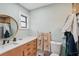 This bathroom showcases a wood vanity and a round mirror over the sink at 7094 Fairway Bend Cir # 7094, Sarasota, FL 34243