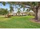 Charming home featuring a lush green lawn, mature trees, and well-maintained landscaping at 7094 Fairway Bend Cir # 7094, Sarasota, FL 34243