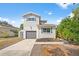 Two-story home with gray garage door, shed, and tidy landscaping at 7134 2Nd N St, St Petersburg, FL 33702