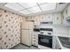 Classic kitchen with wallpaper, ample cabinetry, and modern appliances, perfect for everyday cooking at 7321 Central Ave # 203, St Petersburg, FL 33710
