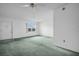 Well-lit living room featuring neutral walls, green carpet, and a view of the community at 7321 Central Ave # 203, St Petersburg, FL 33710