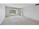 Bright living room with sliding glass doors leading to a balcony and view of community grounds at 8703 Bardmoor Blvd # 203, Seminole, FL 33777