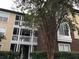 An attractive condo community featuring brick and siding, white railings, and mature landscaping at 10114 Winsford Oak Blvd # 517, Tampa, FL 33624