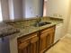 Kitchen featuring wood cabinets, granite countertops, stainless steel sink, and white appliances at 10114 Winsford Oak Blvd # 517, Tampa, FL 33624