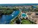 Scenic aerial view showcasing a community center alongside a picturesque lake, golf course, and residential area at 1102 Emerald Dunes Dr, Sun City Center, FL 33573