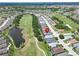 Aerial view of a community along a golf course and pond with manicured landscaping at 1102 Emerald Dunes Dr, Sun City Center, FL 33573