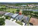 Stunning aerial view showcasing a desirable neighborhood, a beautiful pond, and an adjacent golf course at 1102 Emerald Dunes Dr, Sun City Center, FL 33573