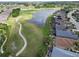 Aerial view of the community featuring a golf course, lake, and a manicured lawn at 1102 Emerald Dunes Dr, Sun City Center, FL 33573