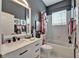 Stylish bathroom featuring a marble vanity, dark accent wall, shower-tub combo, and updated fixtures at 1102 Emerald Dunes Dr, Sun City Center, FL 33573
