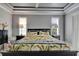 Comfortable bedroom featuring a trey ceiling, neutral walls, and plenty of natural light at 1102 Emerald Dunes Dr, Sun City Center, FL 33573