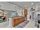 Open concept kitchen with an island, wood cabinets, and adjacent living area at 1102 Emerald Dunes Dr, Sun City Center, FL 33573
